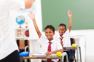 18075617 - elementary school students arms up in classroom